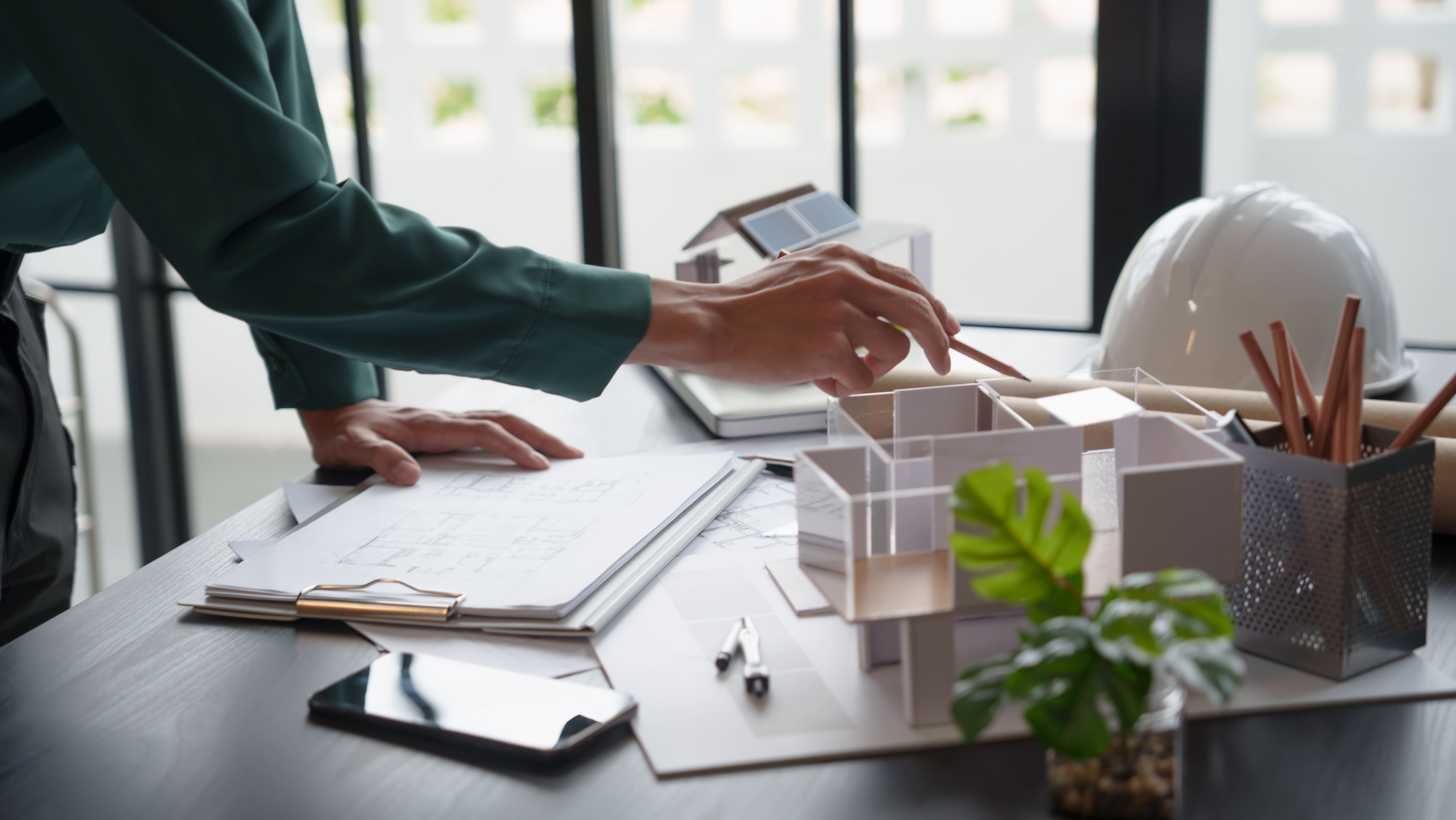 arquitecto mostrando su proyecto con maquetas y planos (1)